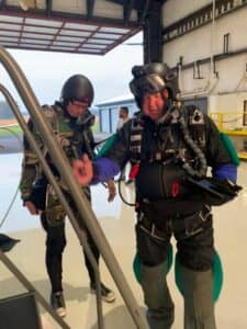 A man wearing skydiving kit