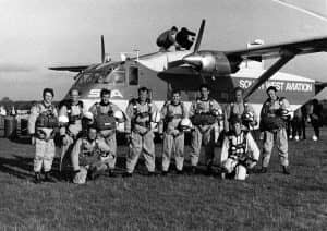 Left to right: John Harrison, Tony Unwin, Terry Hagan, Jim Crocker,Mike O’Brien, Guy Sutton, John Beard and John Shankland. Photographers kneeling: Charles Shea-Simonds (stills) and Mark Miller (cine)